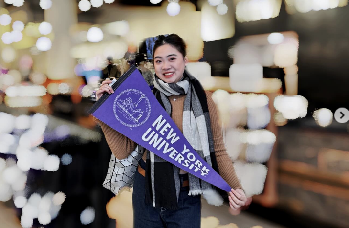 student holding NYu pennant